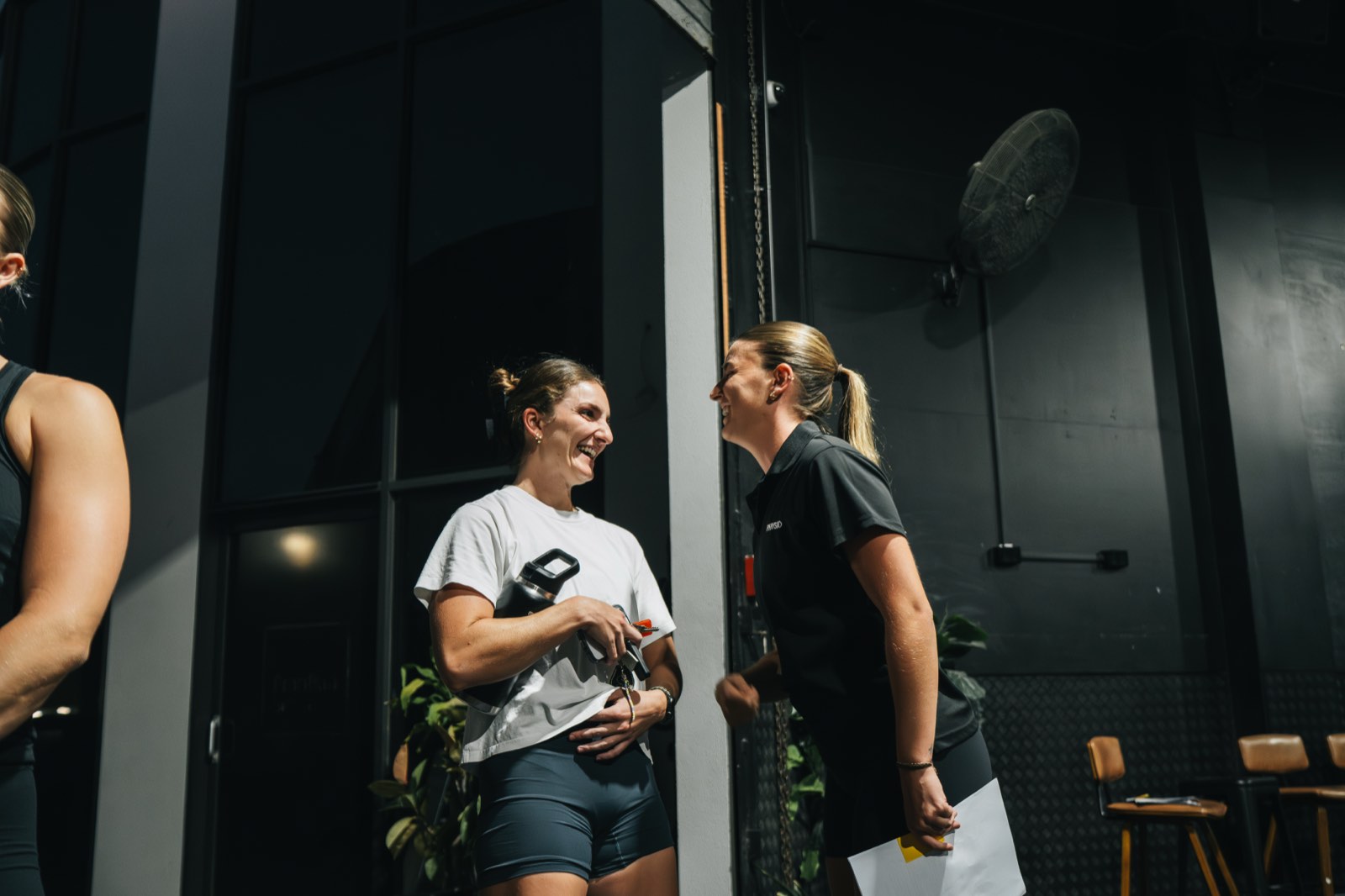 A Science of Fitness practitioner with notes in hand talking a member through her plan