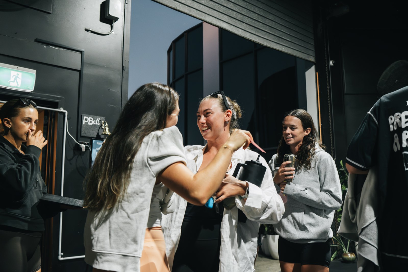 Science of Fitness members laughing together at the studio entrance after a session