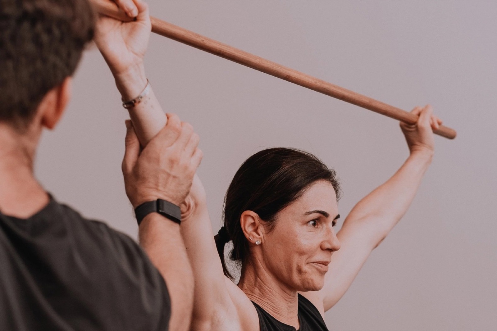 A Science of Fitness practitioner guiding a member through an overhead mobility screen